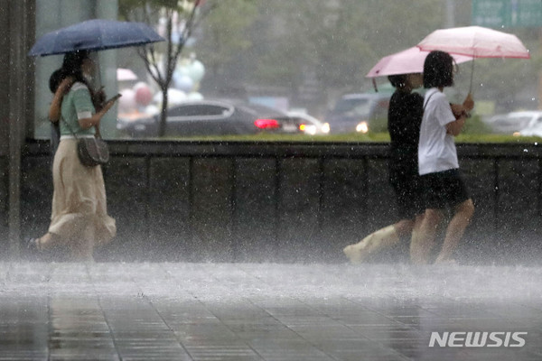 [서울=뉴시스] 최동준 기자 = 중부 지방에 호우특보가 발효된 8일 서울 을지로입구역 인근에서 시민들이 쏟아지는 비를 피해 발걸음을 재촉하고 있다.